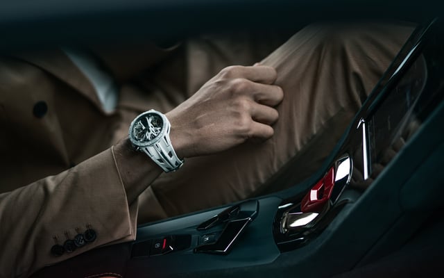 Roger Dubuis watch worn by a man holding a steering wheel